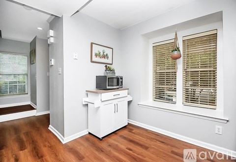 A kitchen with a white countertop and a microwave on it.