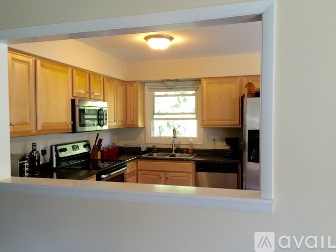 A kitchen with wooden cabinets and a window.
