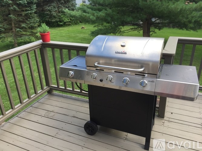 A charcoal grill is on a wooden deck.