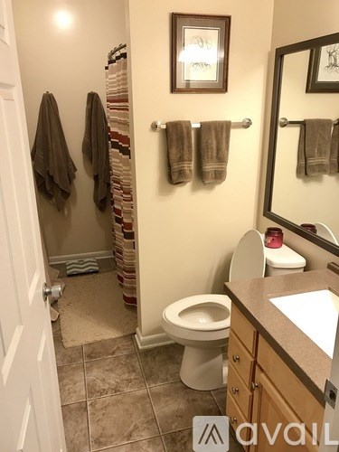 A bathroom with a toilet, sink, and towel rack.