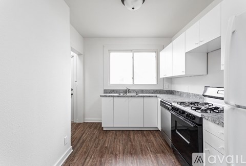 A kitchen with white cabinets and a black stove top oven.
