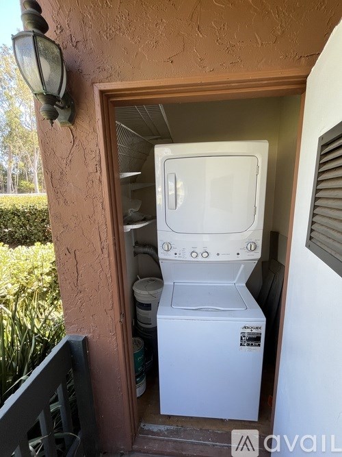 A white dishwasher is sitting in a doorway.