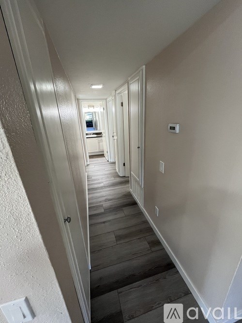 A long hallway with a light switch on the wall.