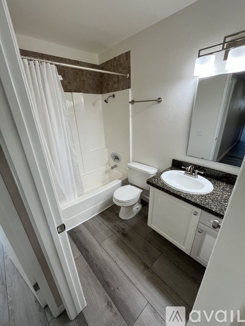A bathroom with a toilet, sink, and shower.