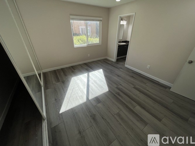 A room with wooden flooring and a window letting in natural light.