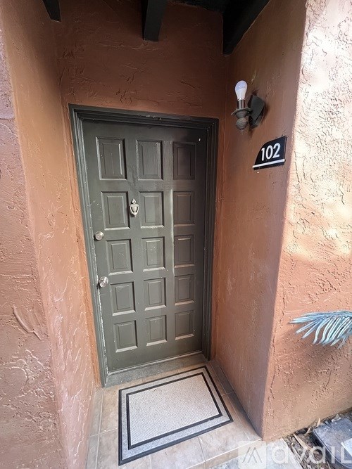 A door with a number 102 on the wall above it.