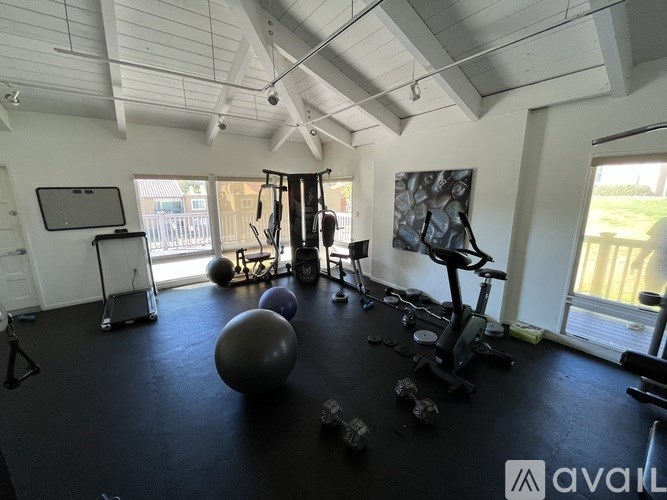 A gym with a variety of equipment including a treadmill, weights, and a stationary bike.