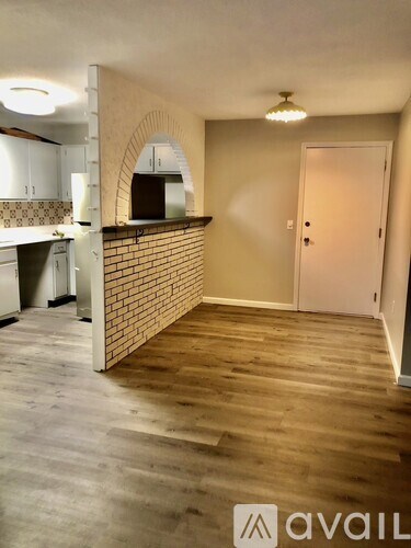 A room with a brick wall and wooden flooring.