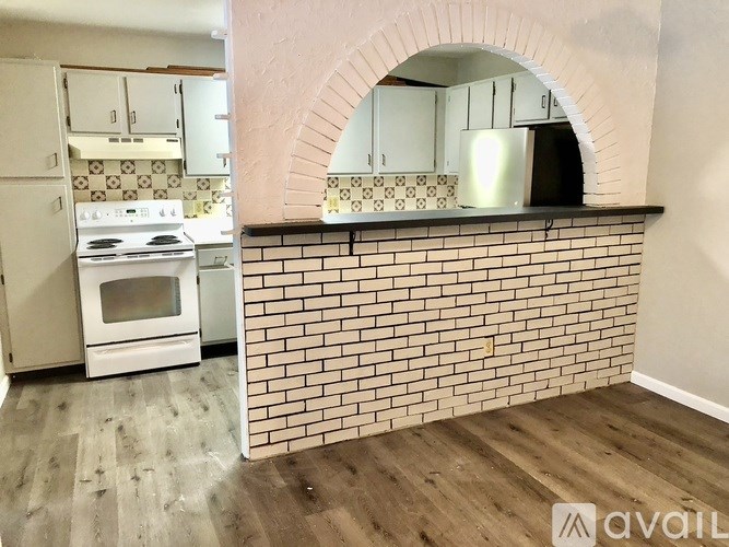 A kitchen with a brick wall and a stove top oven.