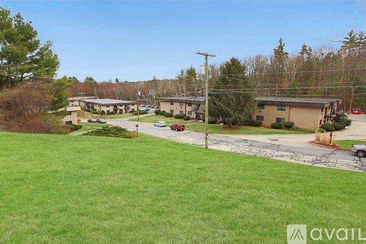 A grassy area with a building and cars in the distance.