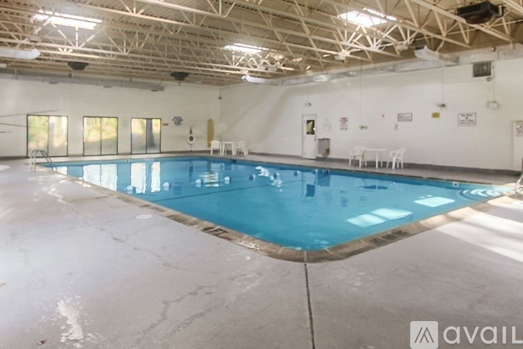 A large indoor swimming pool with a white floor and a wooden ceiling.