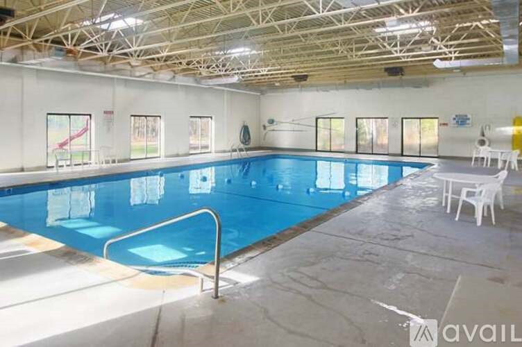 A large indoor swimming pool with a diving board and lane markers.