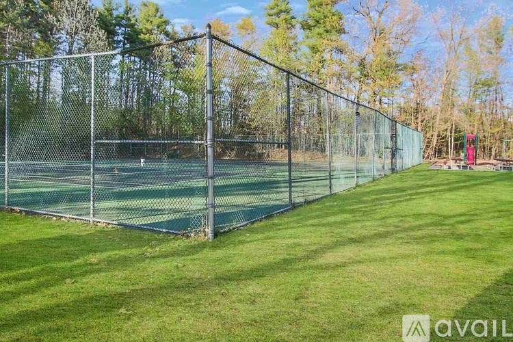 A tennis court is enclosed by a chain-link fence.