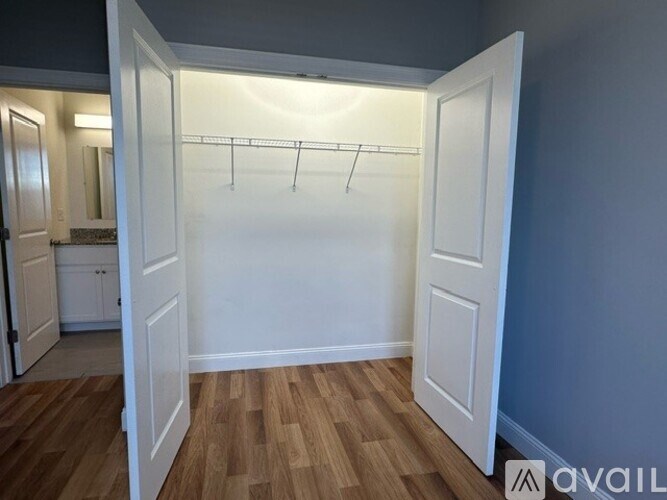 A room with a white door and a wooden floor.