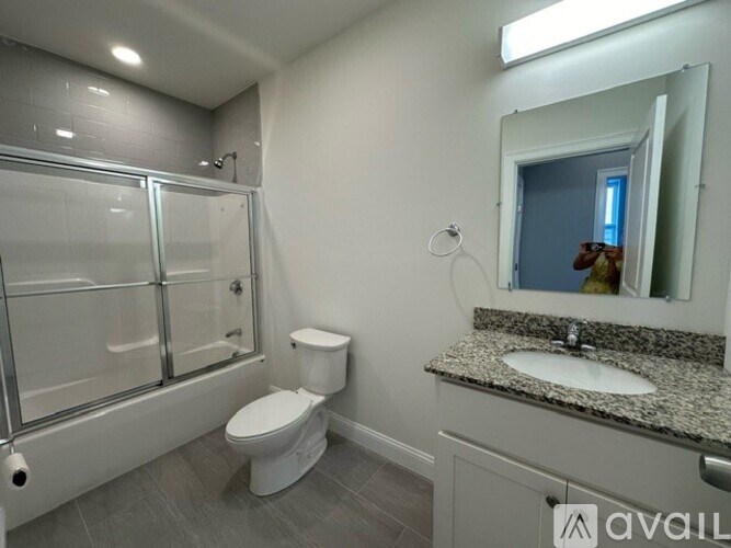 A bathroom with a toilet, sink, and shower.
