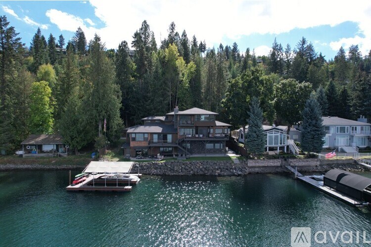 A house is situated on the waterfront with a boat in front of it.