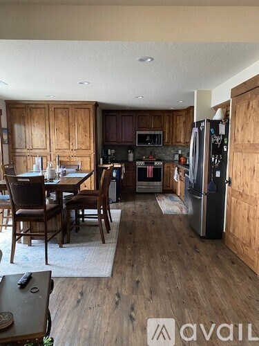 A kitchen with wooden cabinets and a refrigerator.