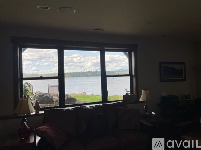 A living room with a large window overlooking a body of water.