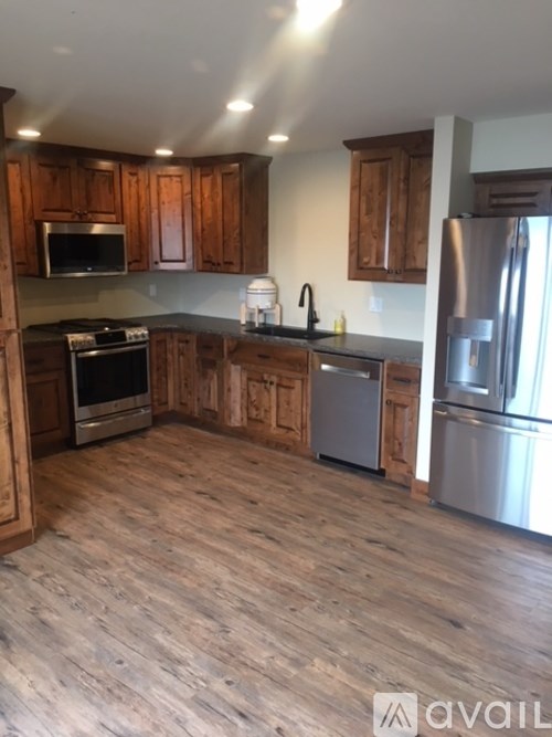A kitchen with wooden cabinets and a stainless steel refrigerator.