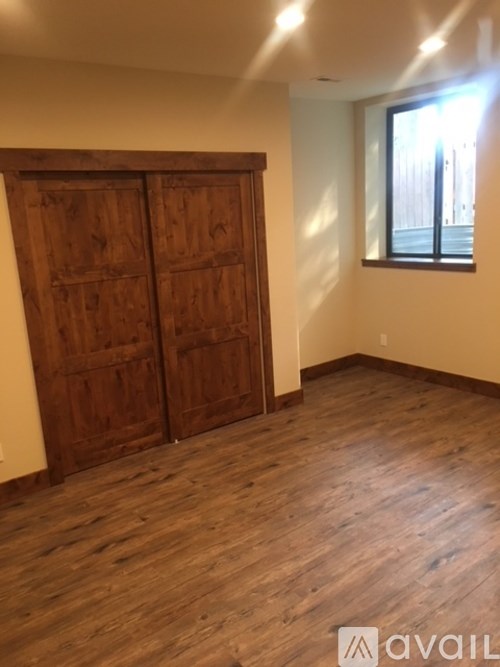A room with a wooden floor and a large wooden door.