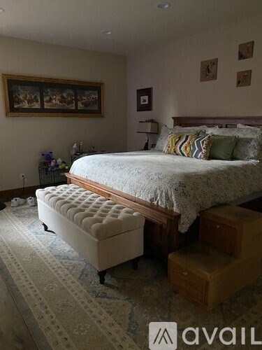 A bedroom with a large bed and a bench in front of it.