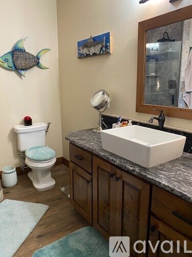 A bathroom with a white toilet, a white sink, and a fish decoration on the wall.