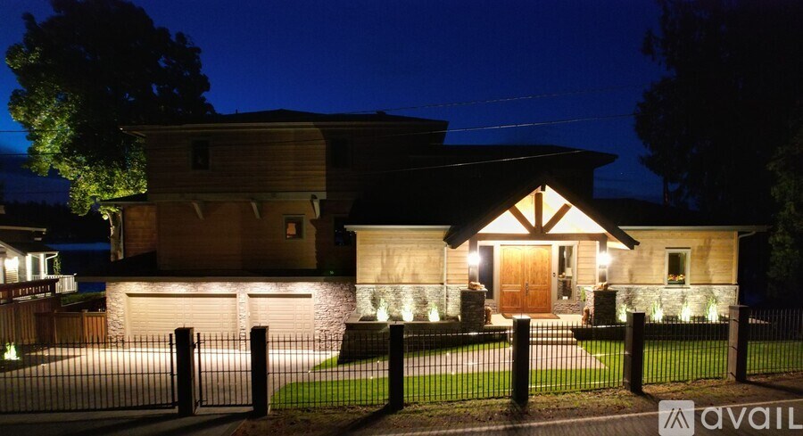A house is lit up at night with a sign that says "available" in the foreground.