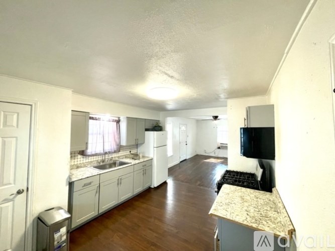 A kitchen with a sink, a dishwasher, and a refrigerator.
