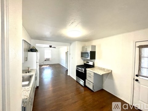 A kitchen with a sink and a microwave on top of a counter.