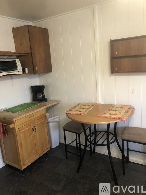 A kitchen area with a table and chairs.
