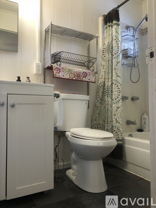A white toilet in a bathroom with a shower curtain.