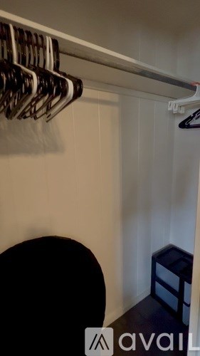 A row of clothes hangers on a rail in a room.