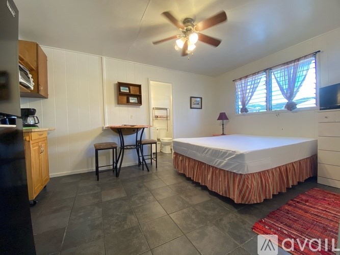 A bedroom with a bed, a chair, and a table.