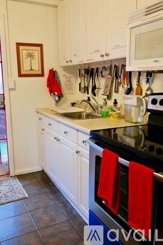 A kitchen with white cabinets and a black stove top.