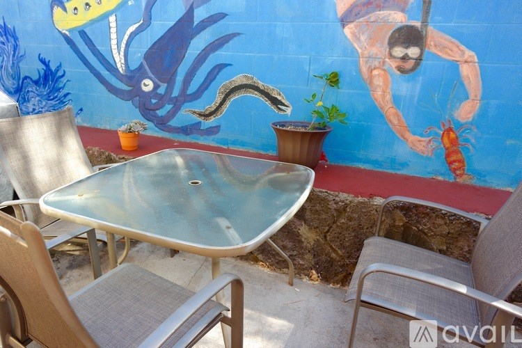 A table and chairs are set up in front of a mural of a diver and a squid.