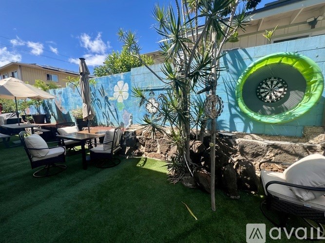 A backyard with a wall mural and a dartboard.
