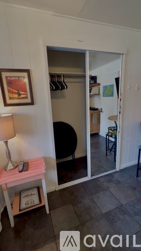 A room with a white door and a lamp on a table.