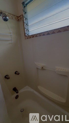 A bathroom with a tub and a window.