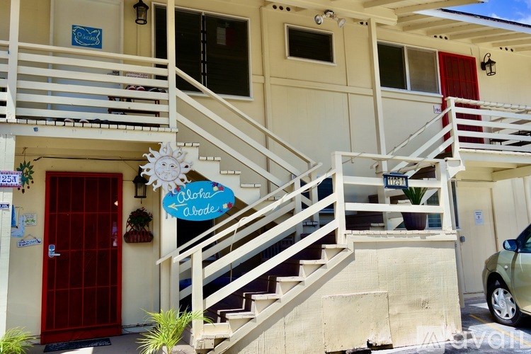 A building with a red door and a sign that says "Aloha Wave".