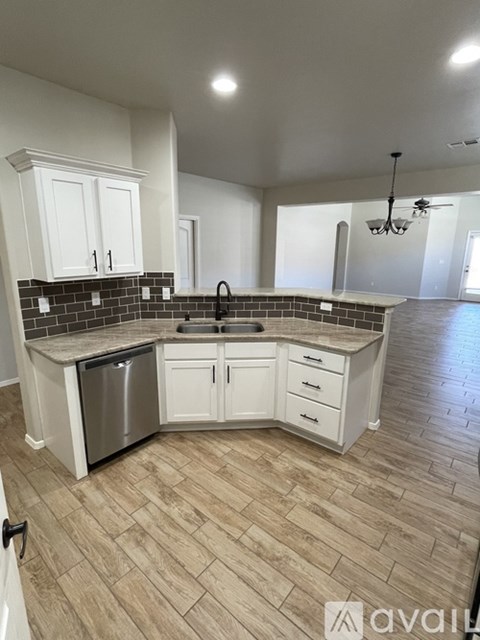 A kitchen with white cabinets and a tiled backsplash.