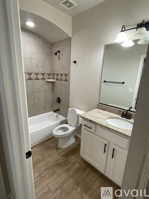 A bathroom with a toilet, sink, and mirror.