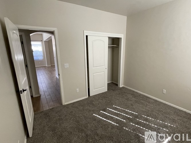 A room with two white doors and a carpet with white lines on it.