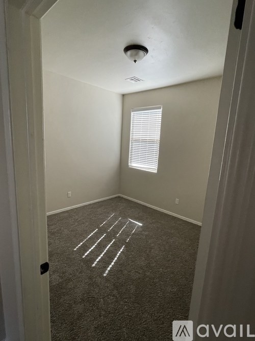 A room with a carpet and a window.
