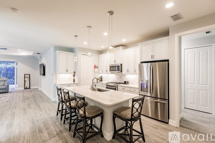 A modern kitchen with a center island and stainless steel appliances.
