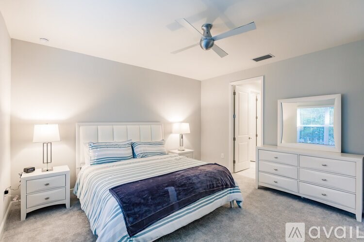A bedroom with a bed, nightstands, and a ceiling fan.