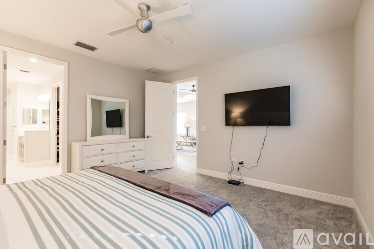 A bedroom with a bed, dresser, and television.
