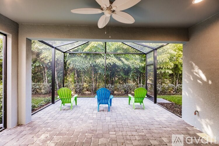 A patio with a ceiling fan and four chairs.