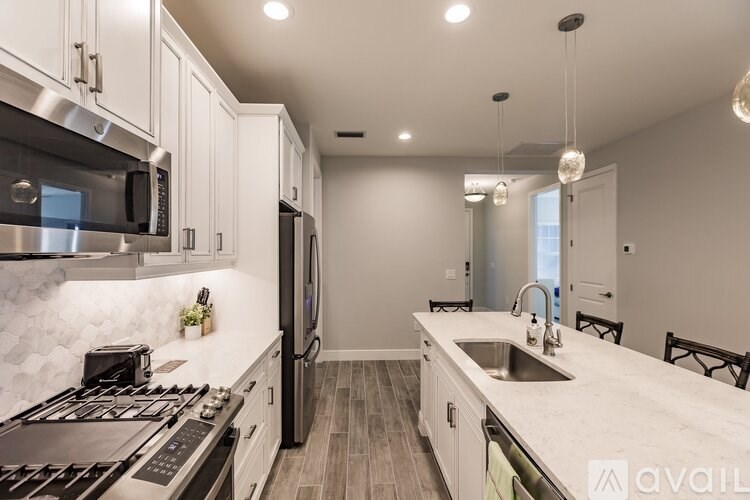 A modern kitchen with stainless steel appliances and white cabinets.