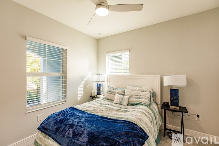 A bedroom with a bed, nightstand, and window.