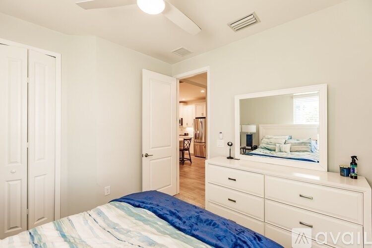 A bedroom with a bed, dresser, and mirror.